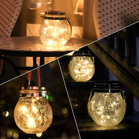 Glob solar LED agățat de o ramură, luminând o grădină cu lumină caldă-led-box.ro
