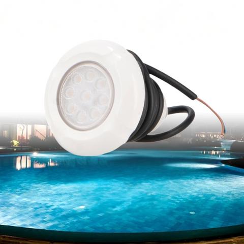 Spot LED RGBW submersibil montat într-un colț de piscină, cu reflexii pe apă.
